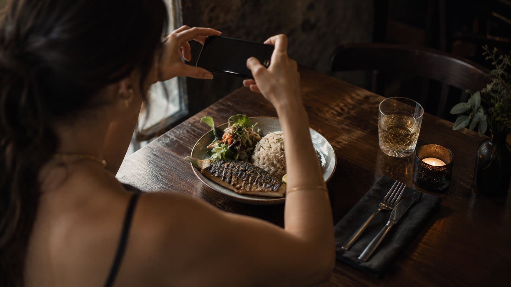 A client photographing her lunch plate with her phone